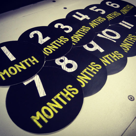 Monthly baby stickers. Simple black and yellow chalk bodysuit infants month labels